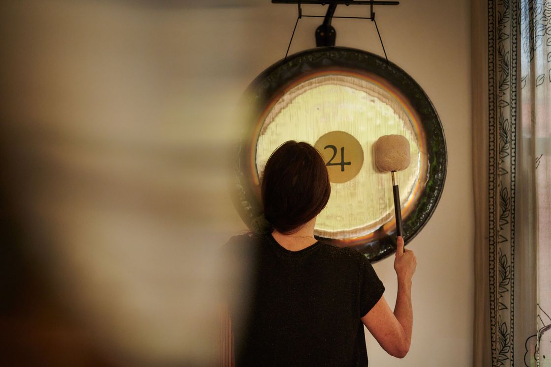 A player strikes a Paiste gong, seen through a soft blur